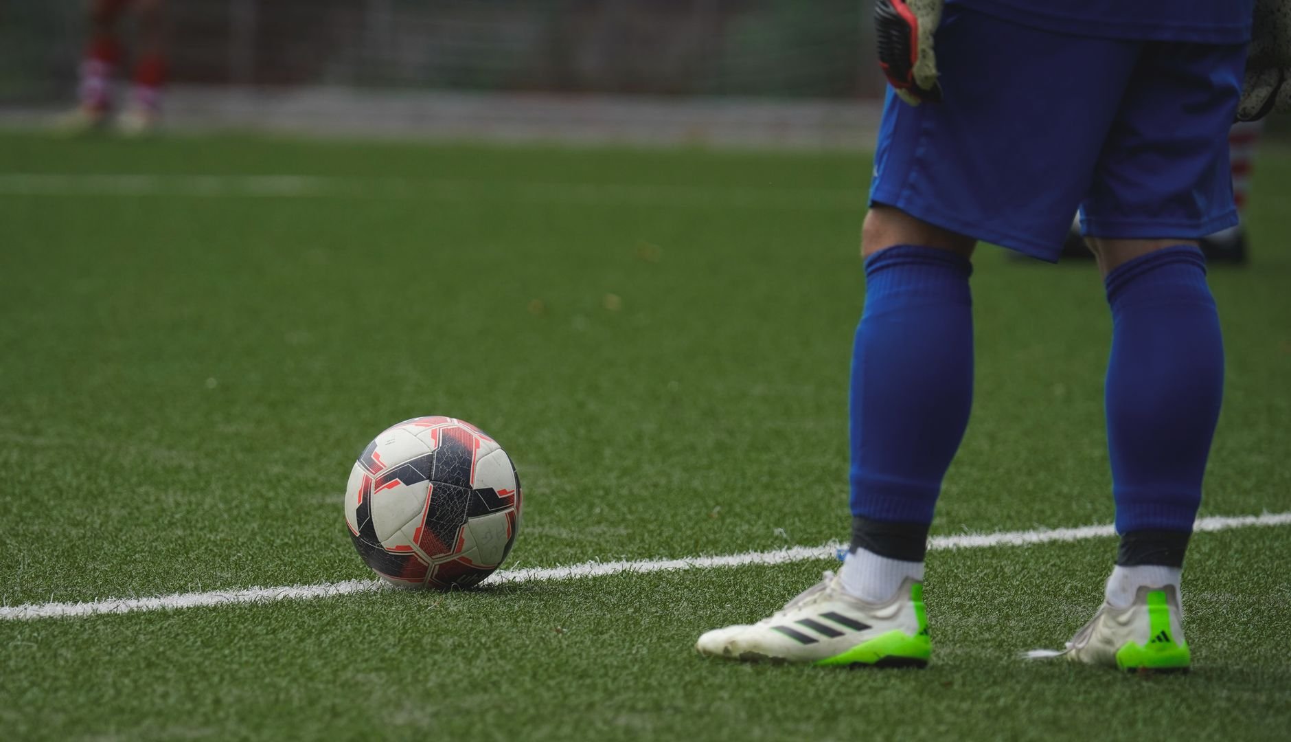 Jugador de fútbol junto al balón en un campo de hierba